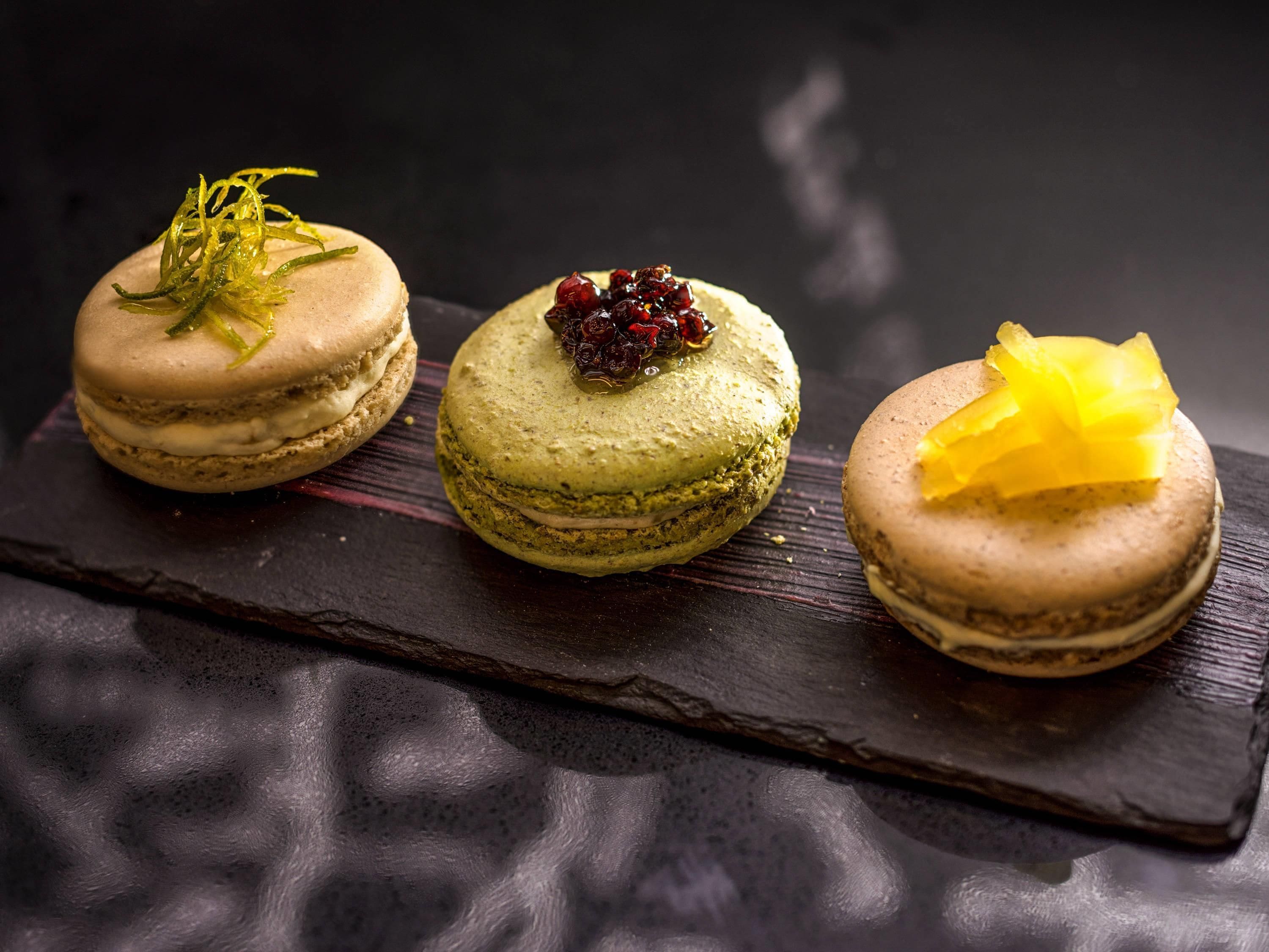 Trois macarons présentés sur une ardoise.