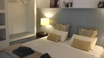 Un lit bien fait, avec deux oreillers, une lampe de chevet et une serviette pliée posée sur le lit.