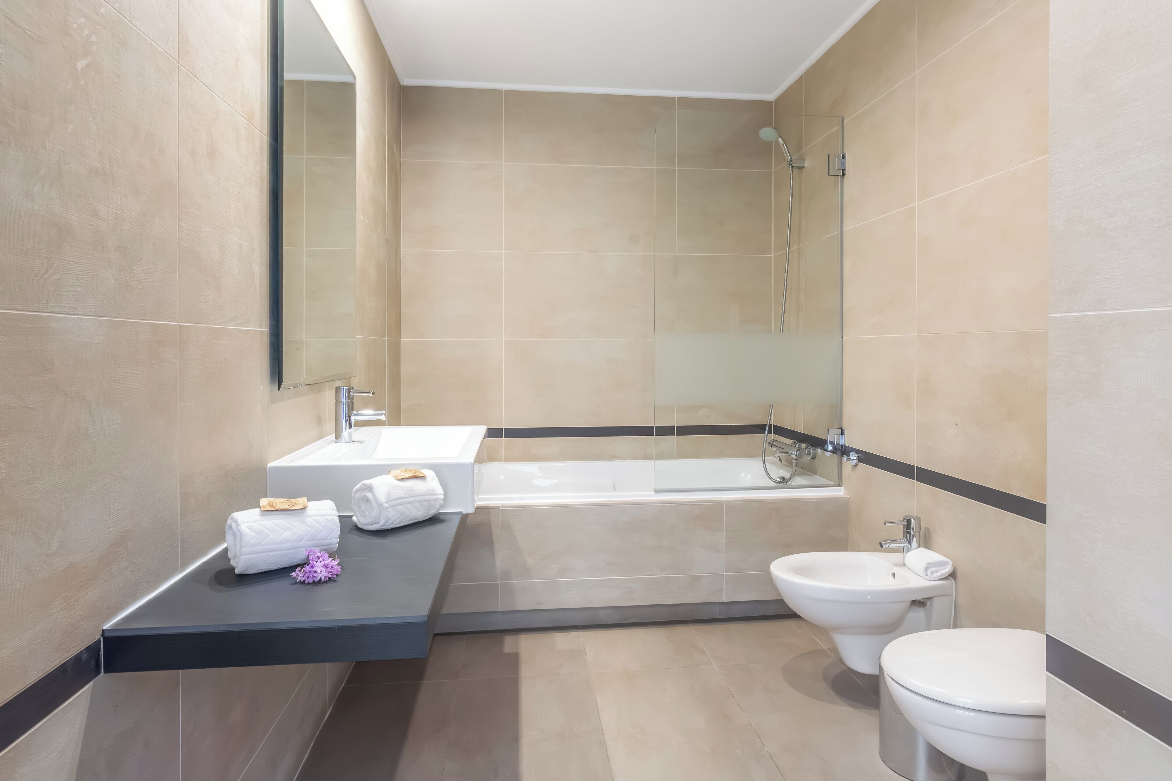 A modern bathroom with a bathtub, a bidet, and a toilet.