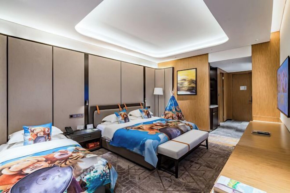 Una habitación de hotel con una cama grande, un escritorio y un televisor.