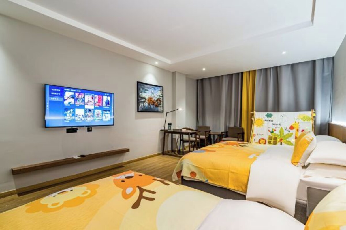 Ein Hotelzimmer mit zwei Betten, einem Fernseher, einem Schreibtisch und einem Stuhl.