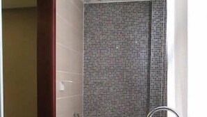 A small bathroom with a toilet, sink, and shower area. - Jiangnanchun Hot Spring Resort Hotel (Zhengzhou)
