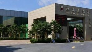 A modern building with a large entrance and palm trees in the foreground. - Jiangnanchun Hot Spring Resort Hotel (Zhengzhou)