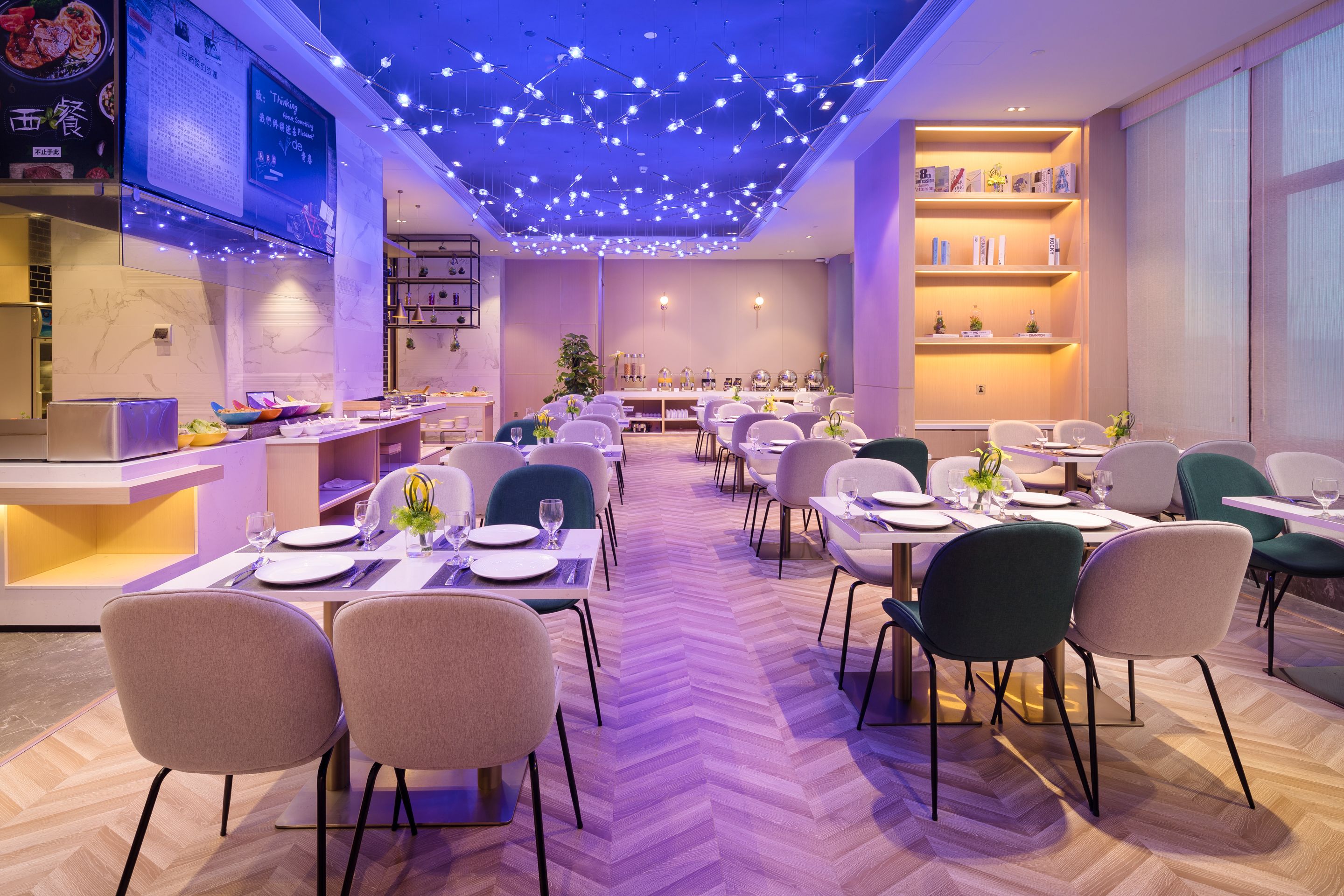 A modern dining area with multiple tables and chairs, a central plant, and a ceiling with string lights.