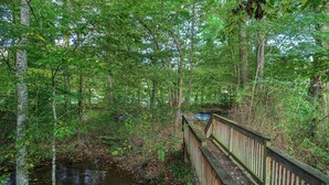 A wooden bridge over a stream in a forested area. - Sweet - 2 Bedrooms, 2 Baths, Sleeps 6 Cabin by RedAwning (Cosby)