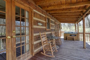 A wooden cabin with a deck, rocking chairs, a hot tub, and a fish decoration on the wall. - Creekside Memories - 2 Bedrooms, 2 Baths, Sleeps 6 Cabin by RedAwning (Cosby)