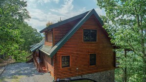 A log cabin with a stone foundation, a wooden deck, and a gravel driveway. - Mountain View - 2 Bedrooms, 2 Baths, Sleeps 6 Cabin by RedAwning (Cosby)