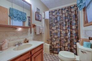 Une salle de bain avec un lavabo, un miroir et des toilettes.