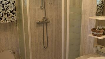 A modern bathroom with a glass-enclosed shower, a toilet, and a vanity with a sink.