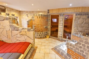 A stone-walled room with a bed, a wooden door, and a small sink. - Ente von Wassertrüdingen (Wassertruedingen)