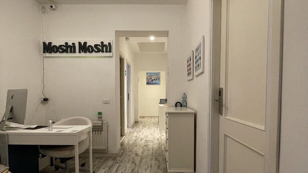 A hallway with a desk, chair, and a sign that reads "Moshi Moshi". - Moshi Moshi B&B (Rome)