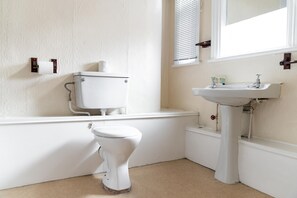 A bathroom with a toilet, sink, and window. - The Royal Hotel Crewe, A BRILLIANT Collection (Crewe)