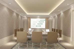 A conference room with a presentation screen, a long table, and chairs.