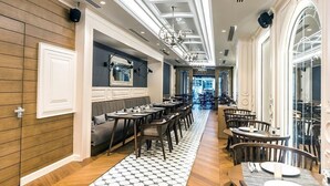 Un ristorante con un lungo bancone, diversi tavoli e un pavimento decorato.
