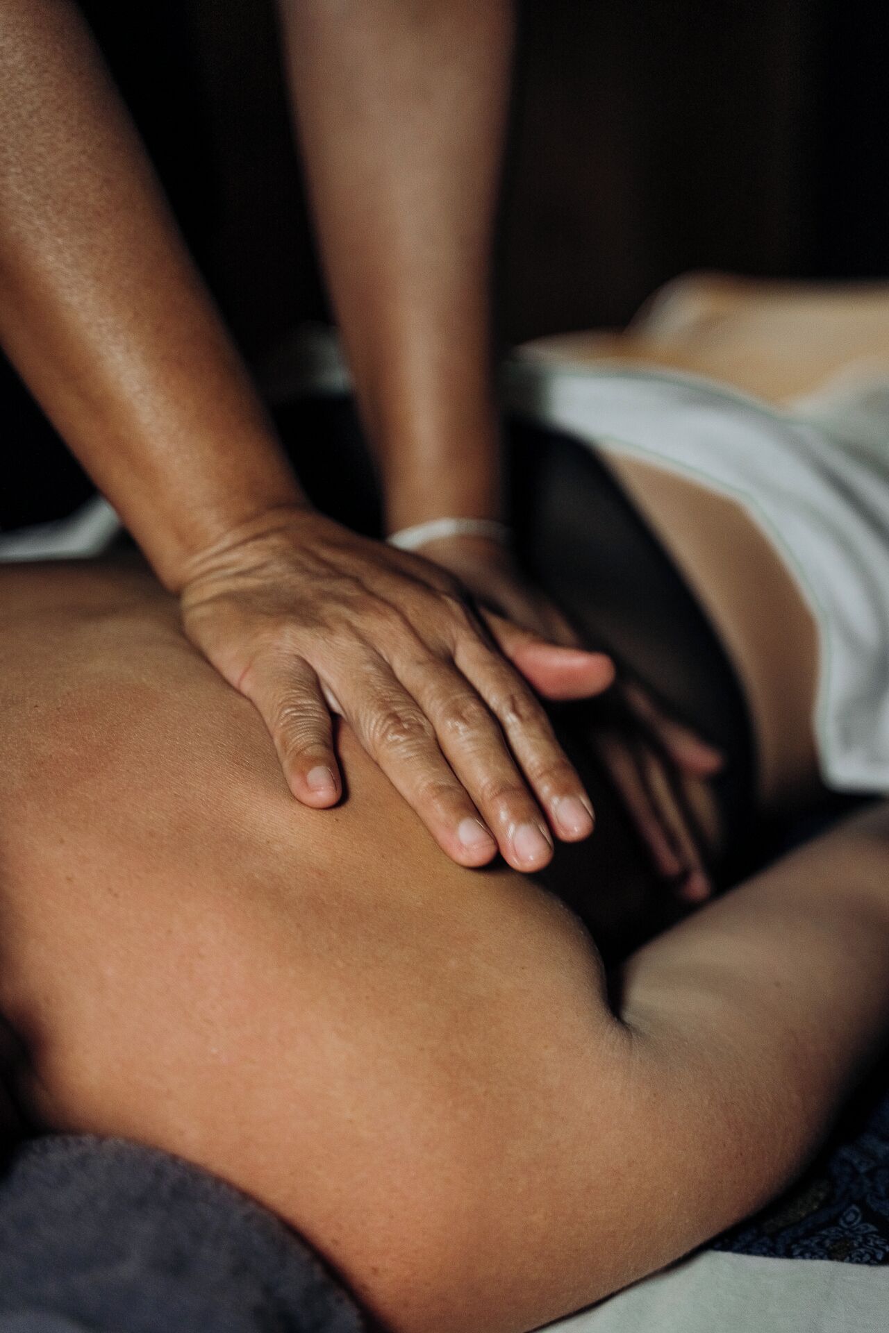 A close-up of a hand performing a massage on a person's back.
