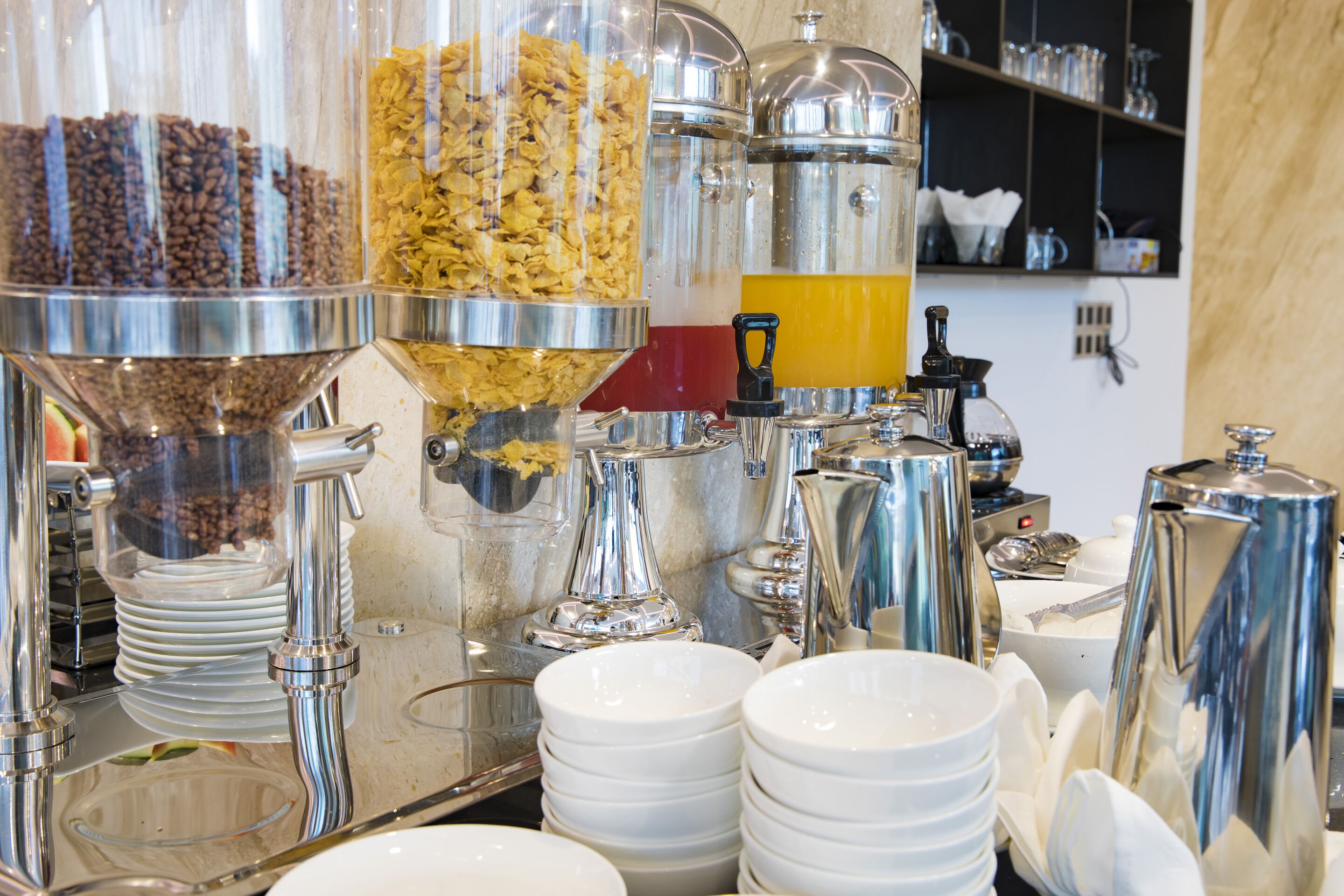 A coffee station with multiple dispensers and a coffee grinder.