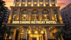 A high-rise hotel with a prominent entrance, multiple balconies, and a clear sky. - Hon Chong Retreat Hotel (Bac Nha Trang)