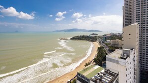 A coastal view with a beach, ocean, and high-rise buildings. - Hon Chong Retreat Hotel (Bac Nha Trang)