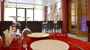 A dining table set with plates, cutlery, and wine glasses, with a 'RESERVÉ' sign indicating a reserved table.