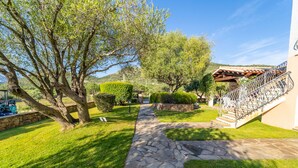 A stone pathway leading to a building with a metal staircase. - Residenza Lu Fraili (San Teodoro)