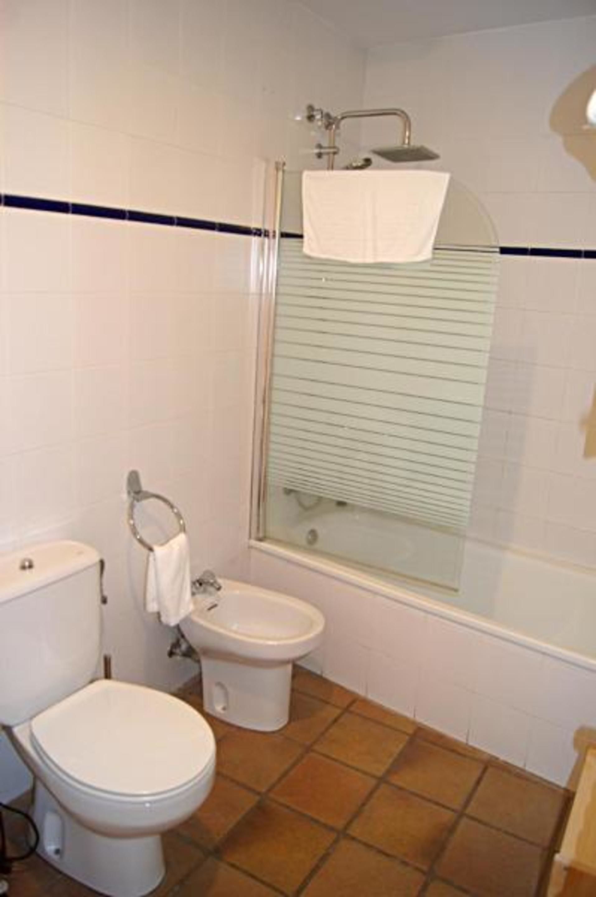 Een badkamer met toilet, bidet en een douchecabine.