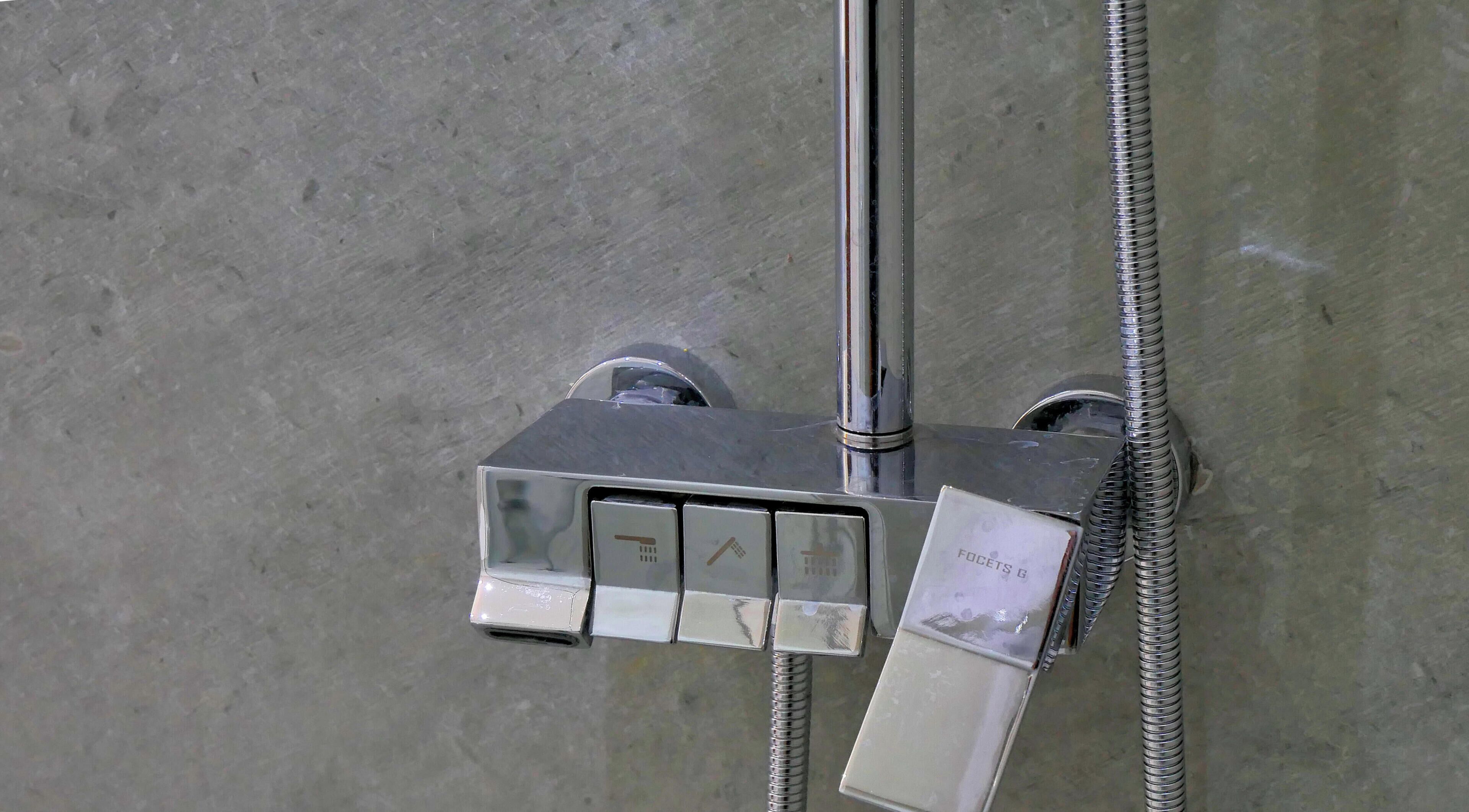 Un panel de control de ducha con un secamanos y una manguera.