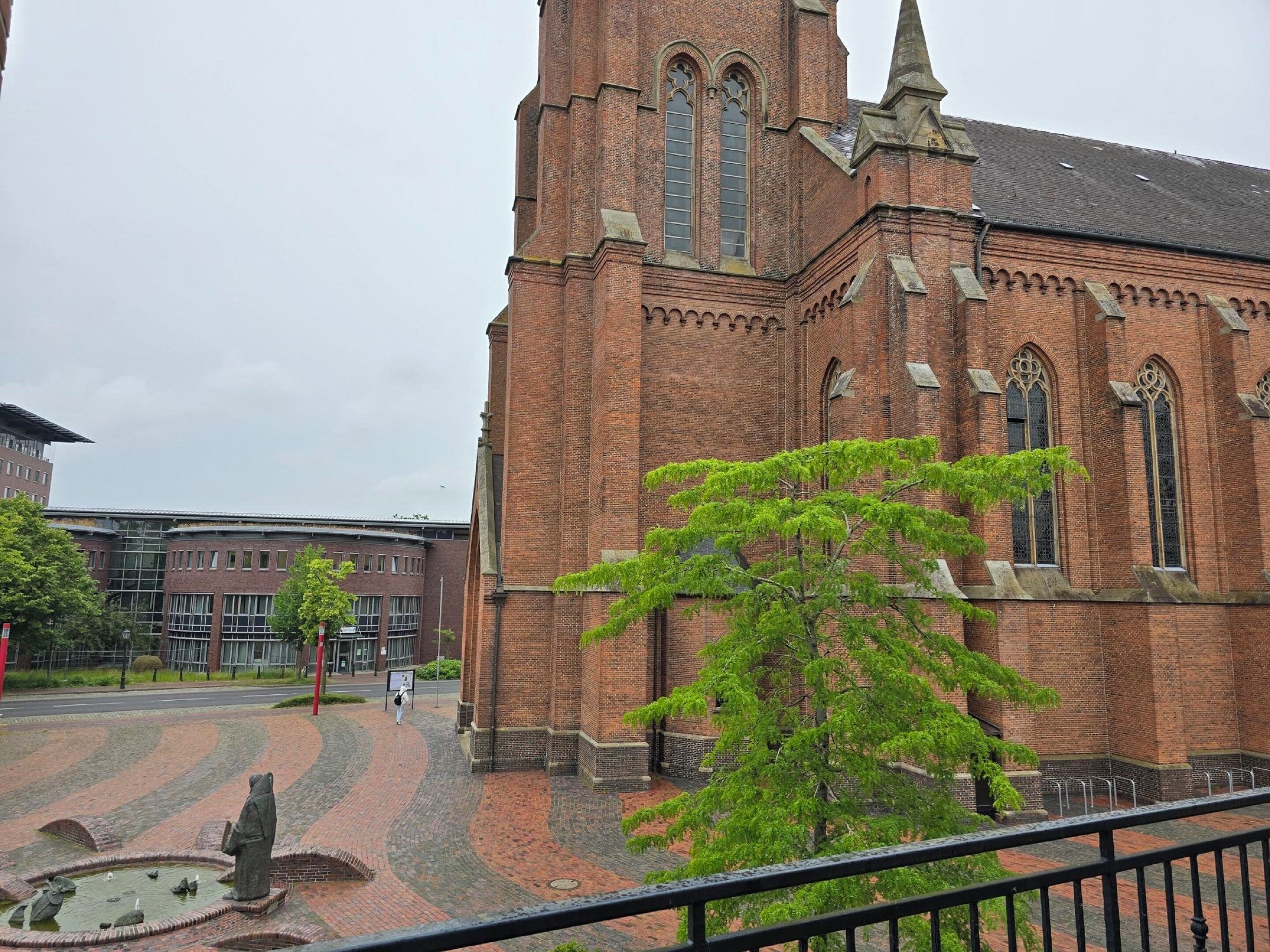 A historic brick church with a tall tower and arched windows.