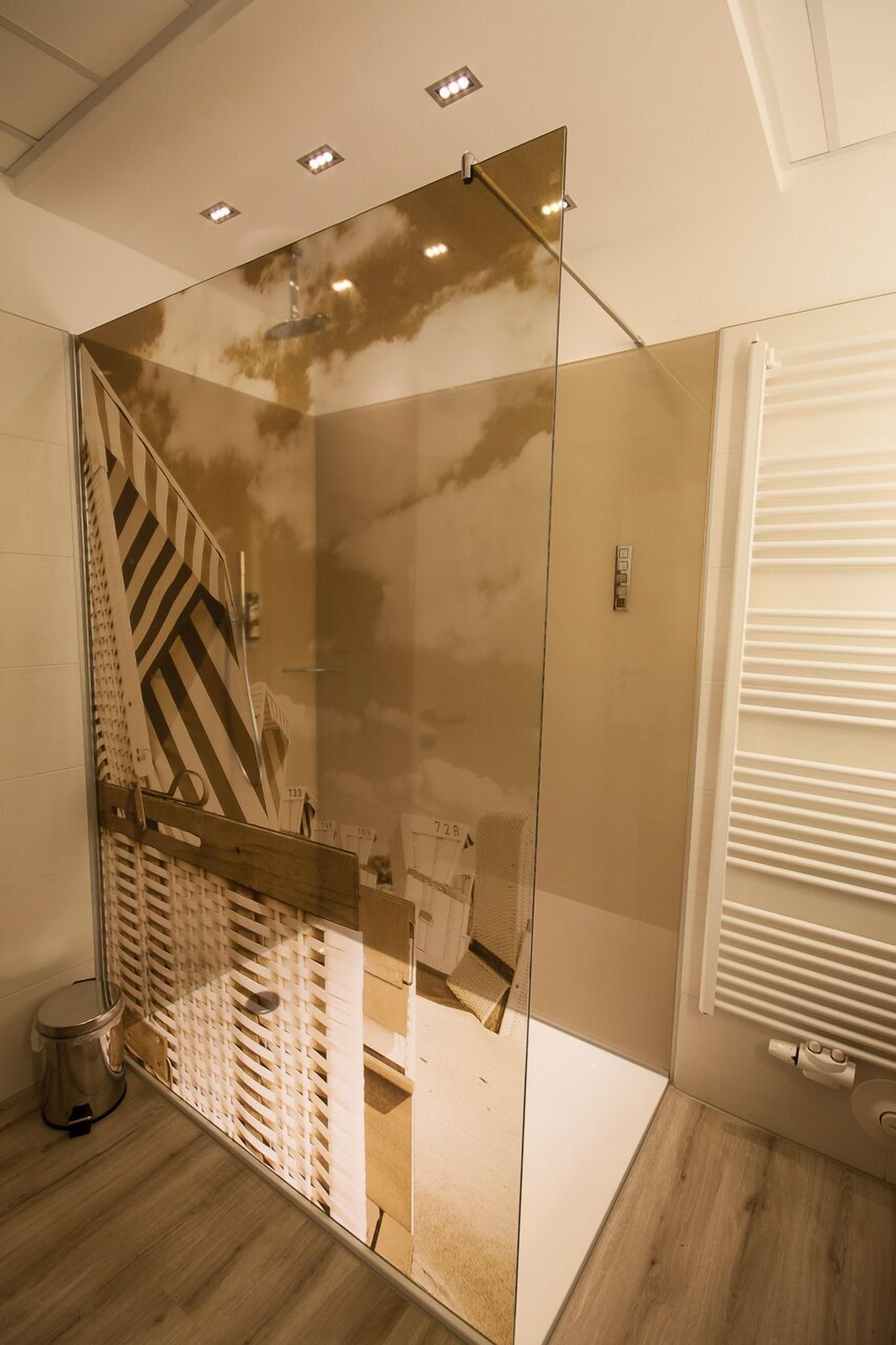 A modern bathroom with a glass partition, a shower area, and a visible staircase.