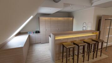 Una cocina moderna con una isla central, taburetes de bar y armarios empotrados.