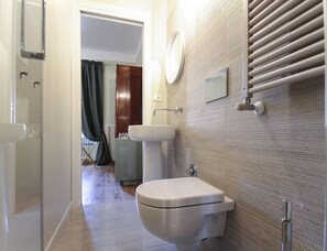 Une salle de bain moderne équipée de toilettes, d’un lavabo et d’une douche.