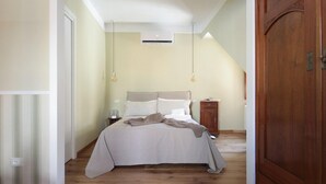 Une chambre à coucher avec un lit, une table de chevet et une armoire.