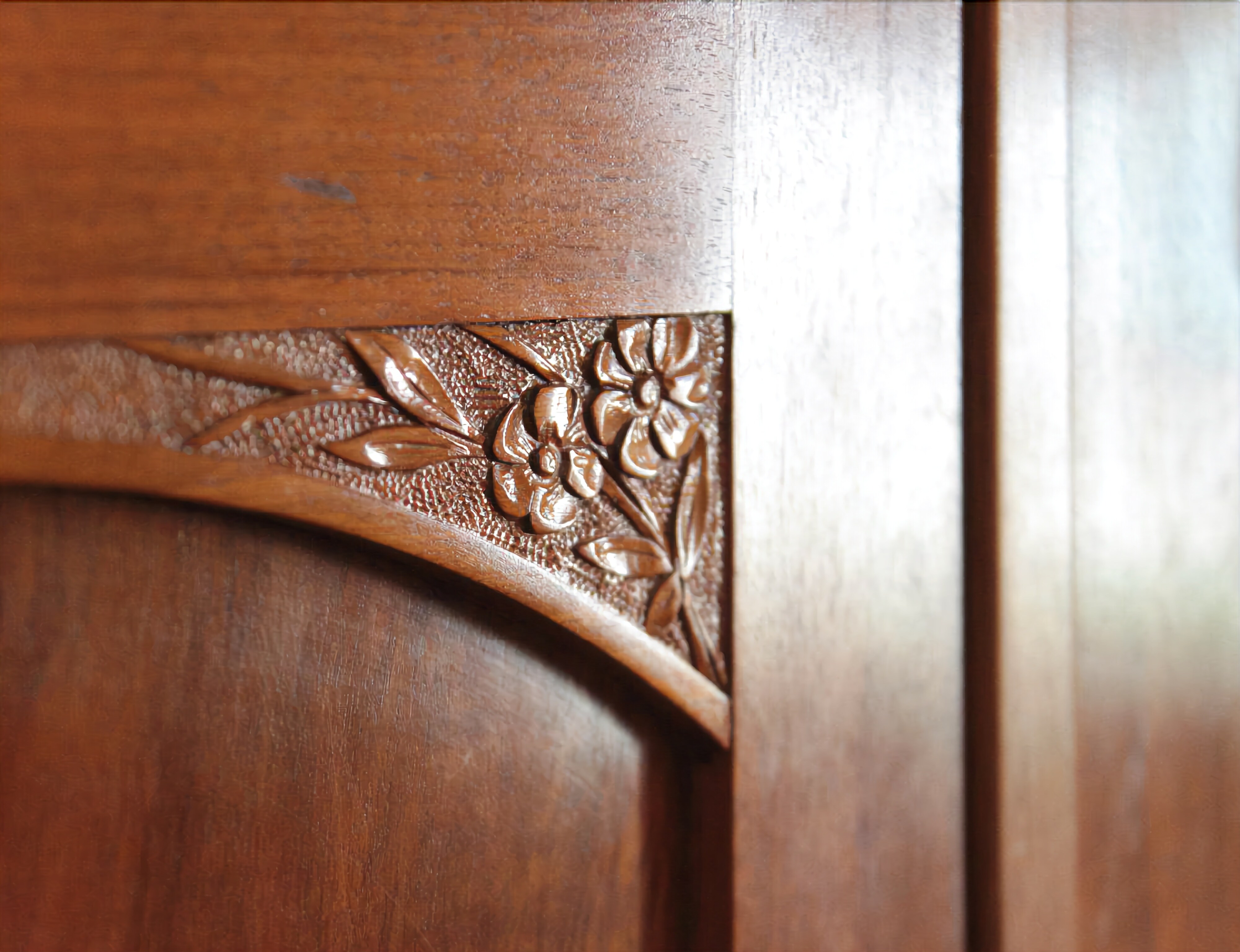 A close-up of a wooden door with intricate floral carvings.