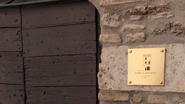 A plaque on a stone wall with a wooden door.