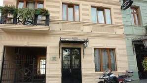 A hotel entrance with a black gate, a double door, and a motorcycle parked outside. - Hotel Brighton (Batumi)