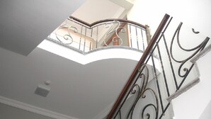 A staircase with ornate metal railings and a white ceiling. - Hotel Brighton (Batumi)