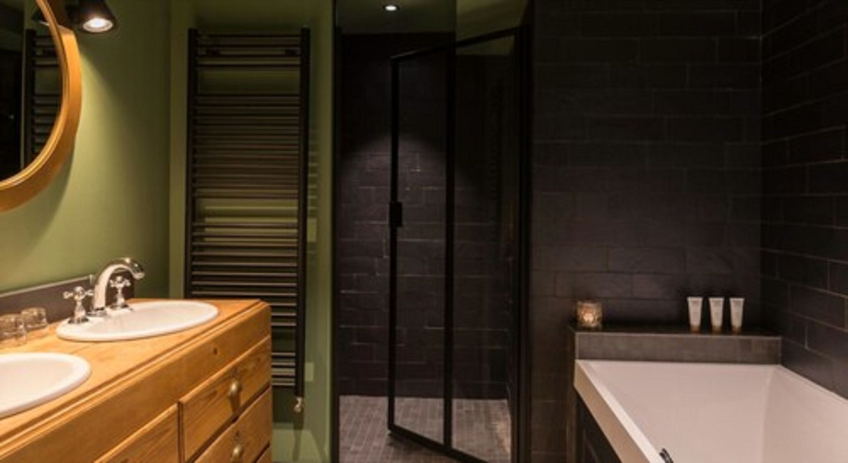 Un baño moderno con dos lavamanos, cabina de ducha de vidrio y un espejo grande.