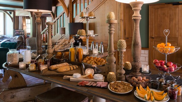 A buffet table with various food items and a fruit display. - Hotel Spa Les Pins De César (Saint-Jouin-Bruneval)