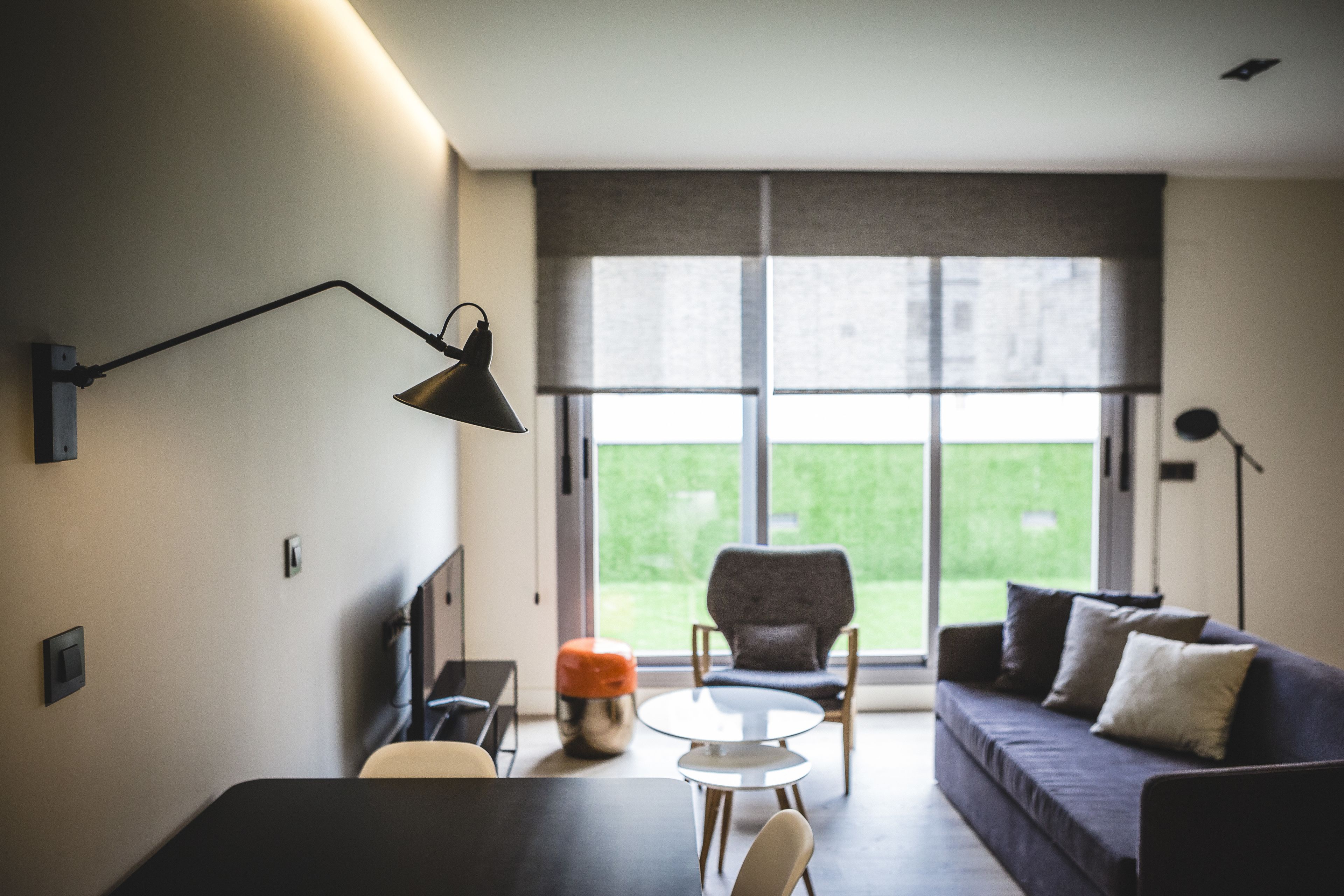 A modern living room with a sofa, armchairs, a coffee table, and a lamp.