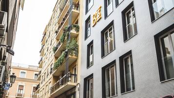 A multi-story building with balconies, a storefront, and a garage entrance.