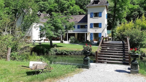 A two-story house with a stone staircase leading to a wooden deck. - Le Moulin de Bénédicty (Saint Gery-Vers)