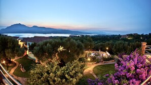 Jardim com paisagismo, caminhos, uma estátua e vista para montanhas distantes.