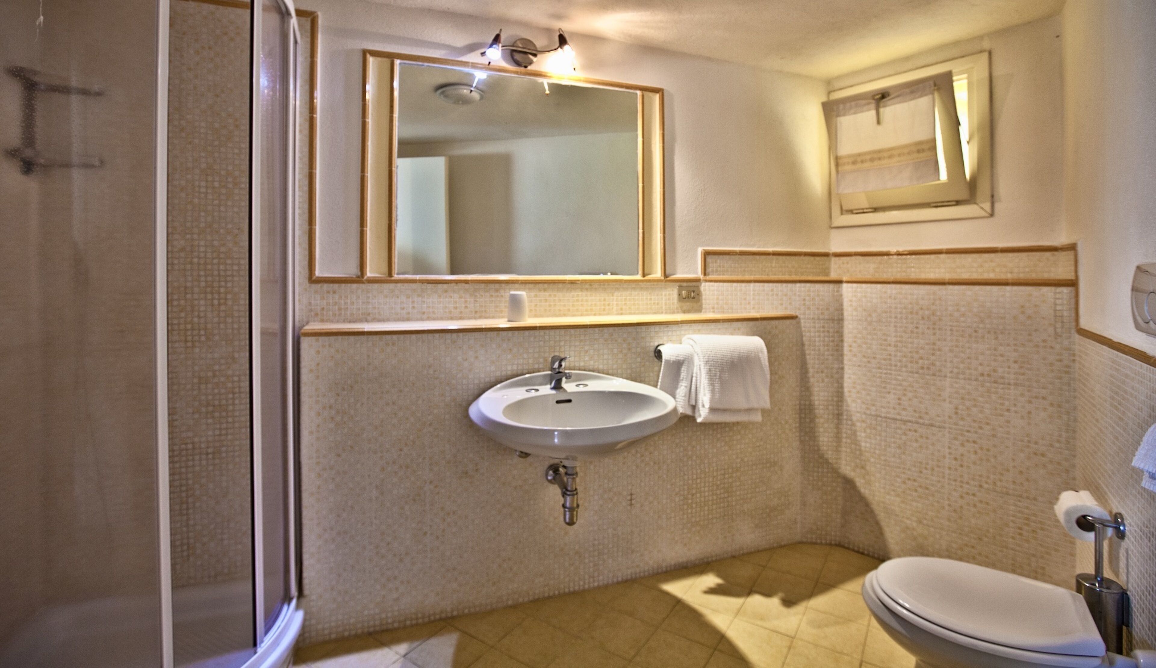 A bathroom with a sink, mirror, and toilet.