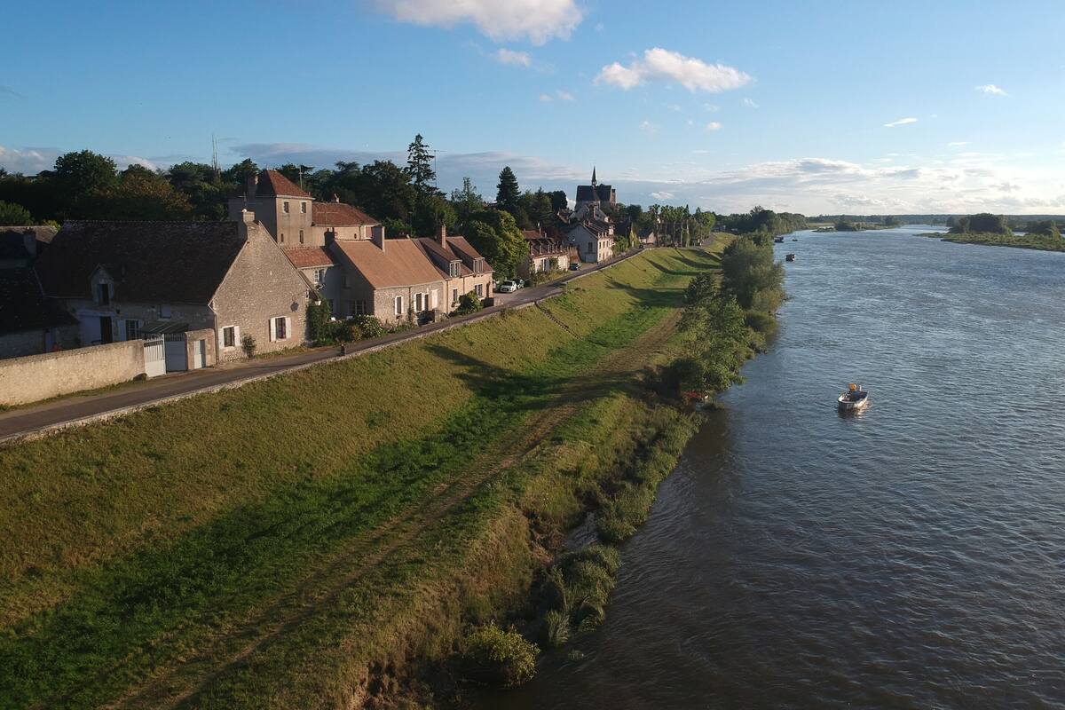Une ville riveraine dotée de bâtiments historiques, d’une route pavée et d’un bateau sur l’eau.