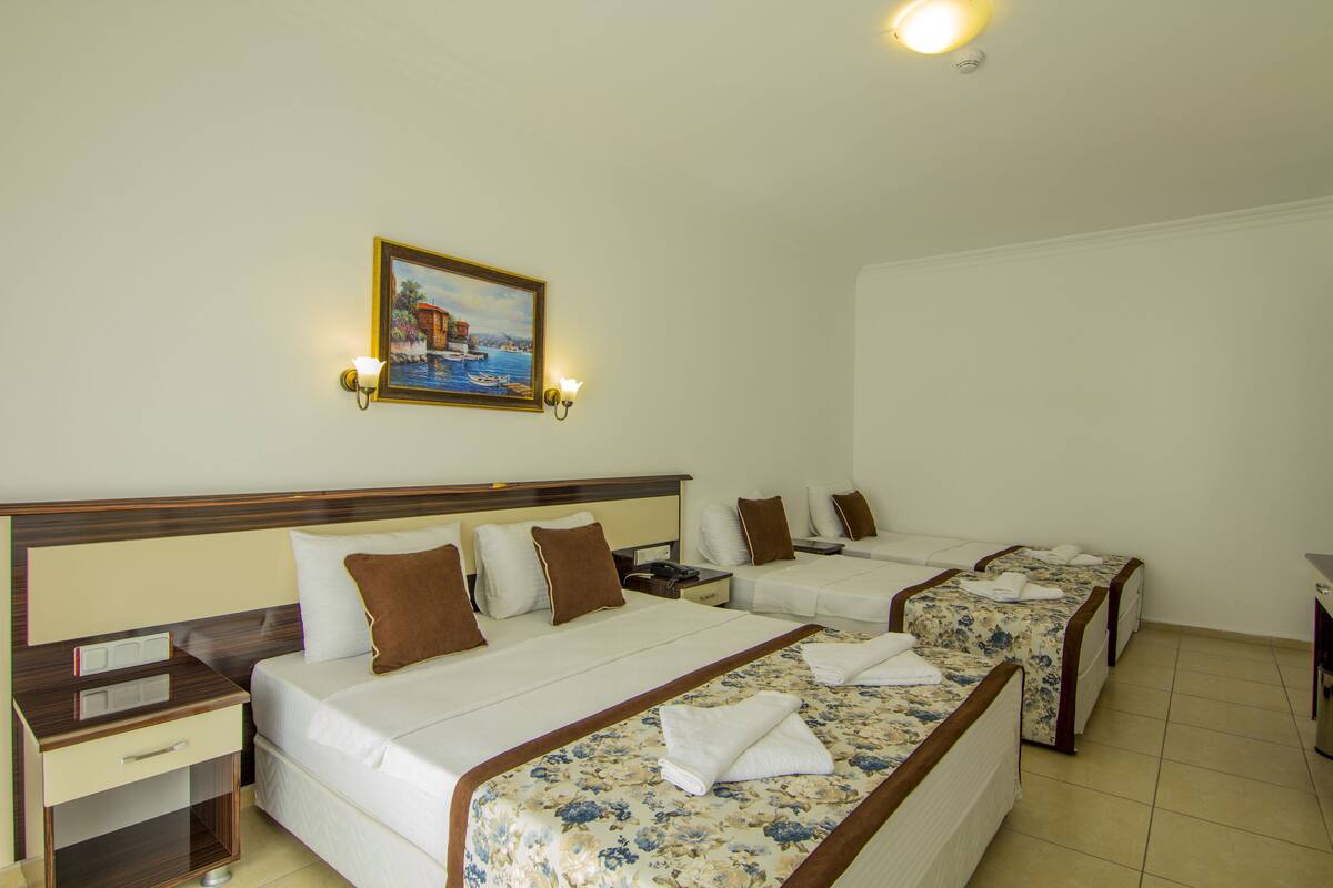 Een hotelkamer met twee bedden, een nachtkastje, een bureau en een schilderij aan de muur.