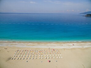 A beach with rows of sun loungers and umbrellas. - Belcekum Beach Hotel (Fethiye)