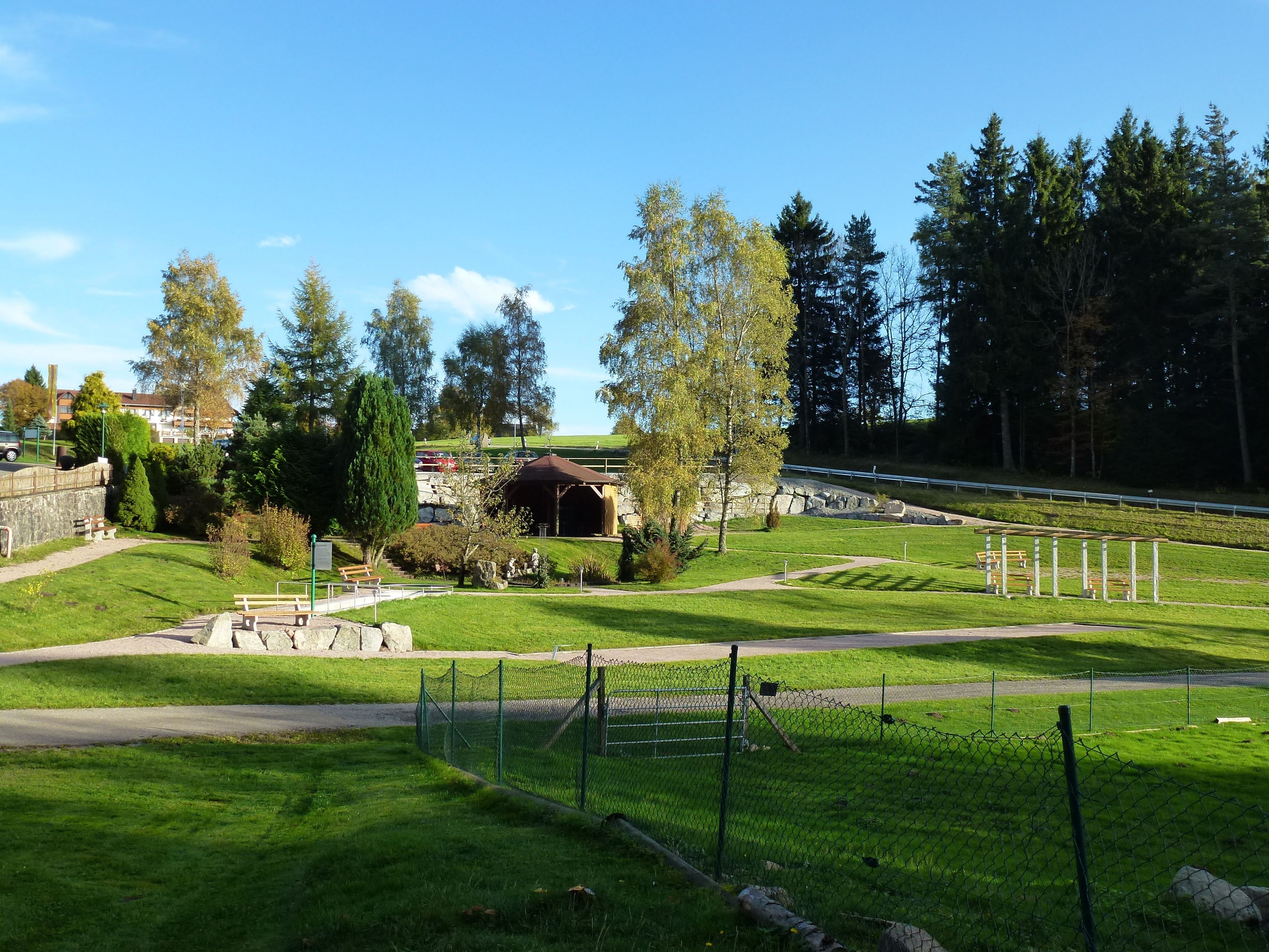 A park with a gazebo, pathways, and a fenced area.
