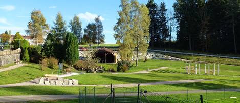 A park with a gazebo, pathways, and a fenced area.