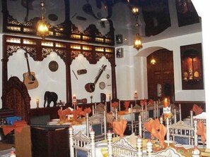 A room with ornate wall decorations, a guitar, and a table set with candles and napkins. - Hotel Starkenburger Hof (Heppenheim)