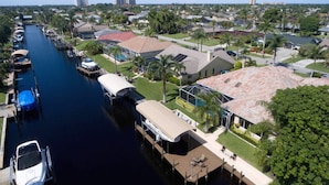 A marina with boats docked, a swimming pool, and residential buildings with a red-tiled roof. - House Bethany by Vacationhit (Cape Coral)