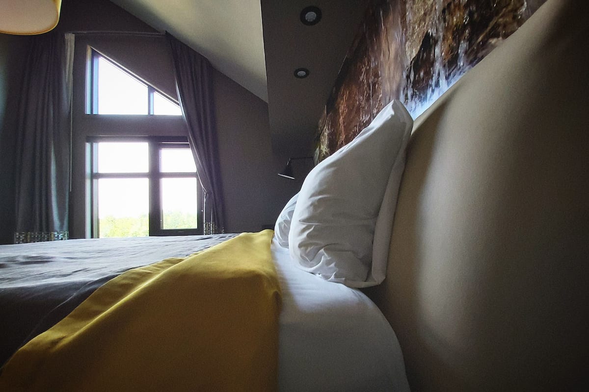 Une chambre d’hôtel avec un lit, une fenêtre et une vue sur l’extérieur.